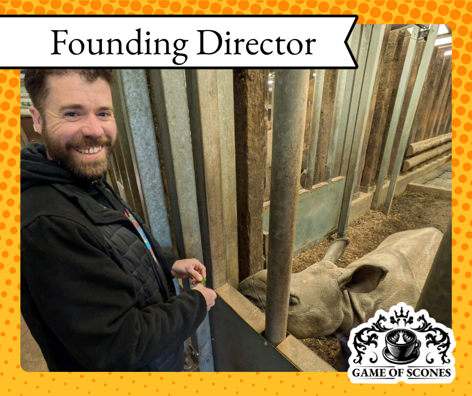 A smiling man, the Founding Director of Game of Scones, feeding a rhinoceros. This friendly 'Meet the Team' photo highlights the approachable leadership behind the Herefordshire community project dedicated to tackling isolation
